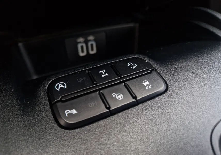 Gros plan sur les boutons de contrôle de fonctions d’aide à la conduite dans l’habitacle du Ford Ranger blanc.