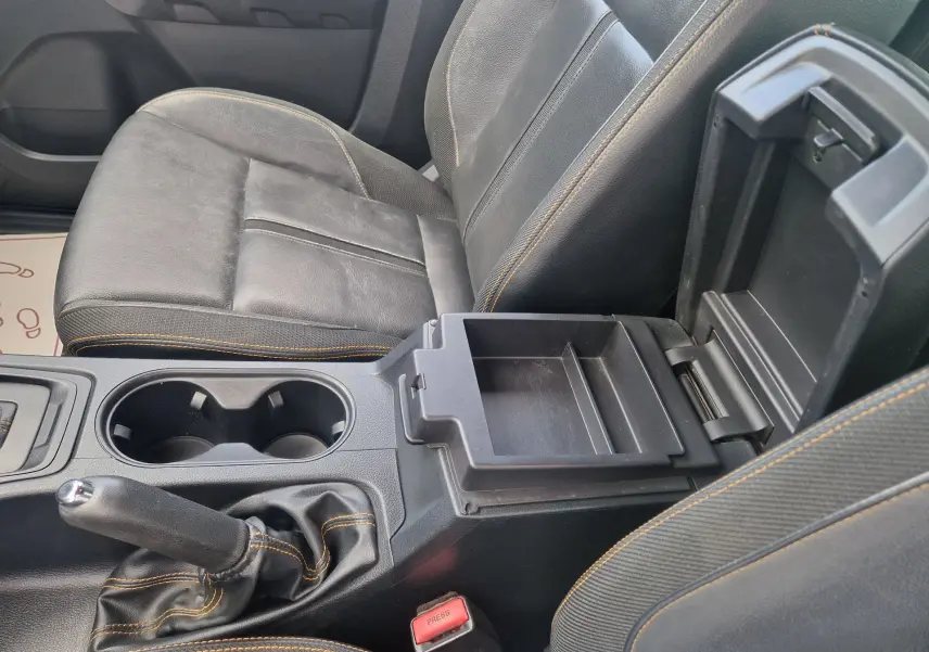 Vue rapprochée de l’intérieur du Ford Ranger Wildtrak 2020, siège noir avec surpiqûres orange et console centrale ouverte.