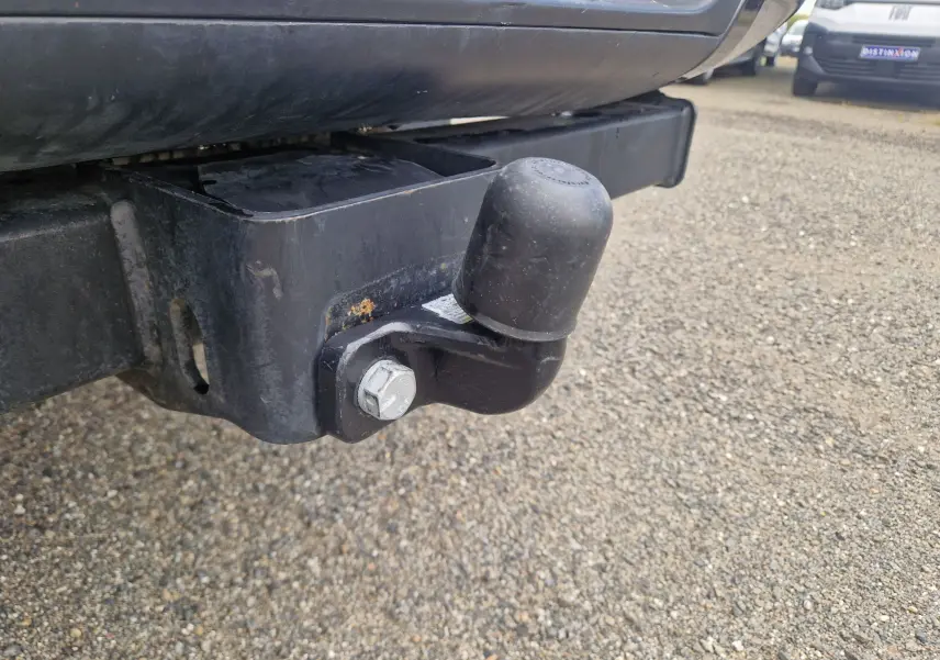 Gros plan sur l'attelage arrière noir du Ford Ranger Super Cabine blanc, avec protection en caoutchouc sur la boule.
