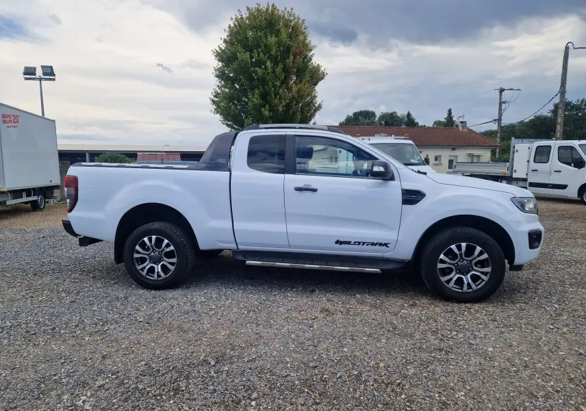 Ford Ranger Wildtrak blanc vu de profil côté gauche, avec cabine étendue et jantes alliage distinctives.