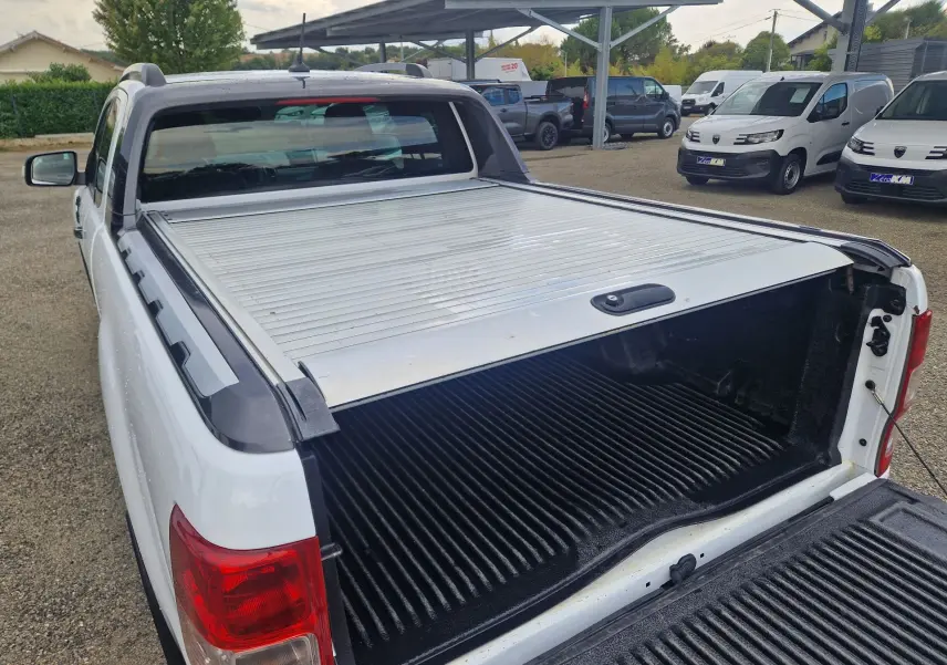 Vue arrière droite du Ford Ranger blanc avec benne ouverte et rideau de plateau coulissant manuel visible.