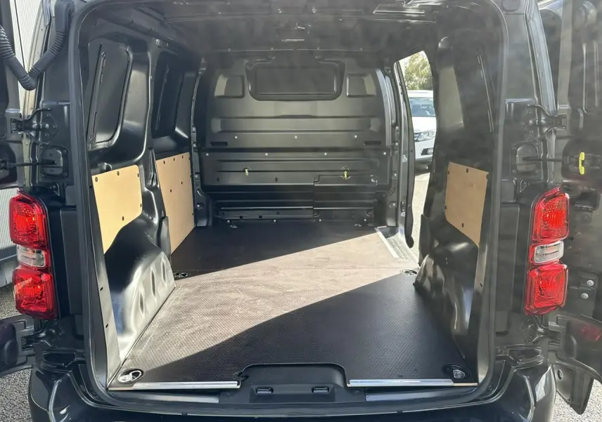 Vue arrière ouverte du FIAT Scudo Fourgon gris Platinium montrant l'espace de chargement avec plancher bois antidérapant.
