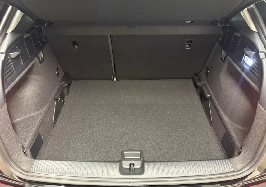 Coffre ouvert d’un Audi Q2 35 TFSI S Line noir Mythic, vue de l’arrière montrant l’espace de chargement vide et éclairé.