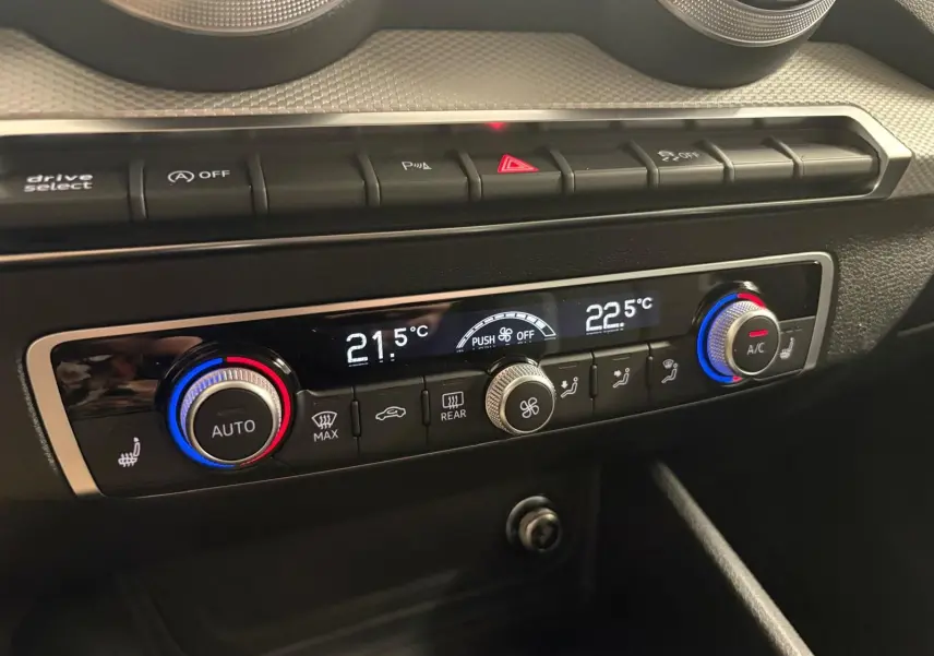 Gros plan sur la console de climatisation digitale de l'Audi Q2 35 TFSI S Line, avec réglages de température affichés.