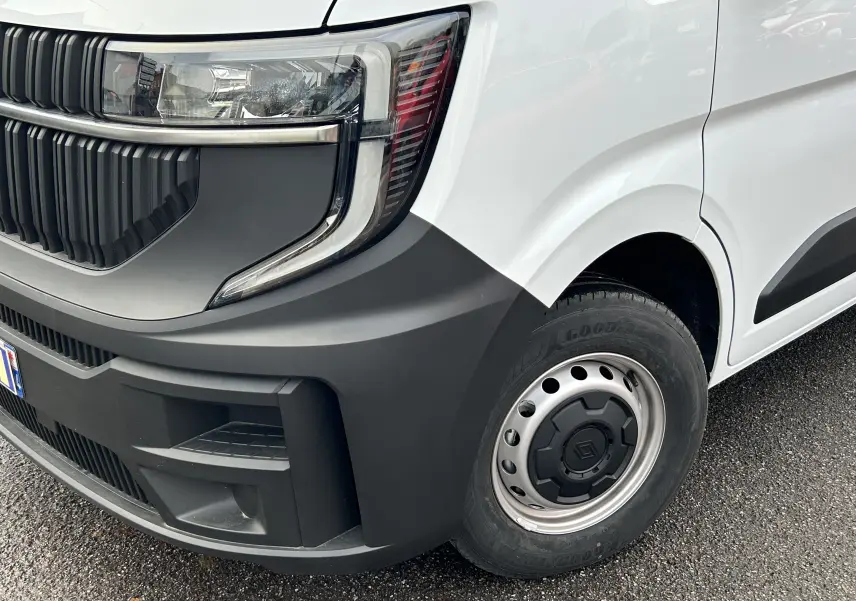 Gros plan sur l’avant droit du Renault Master blanc, mettant en valeur le phare moderne et la roue acier avec enjoliveur noir.