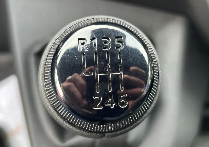 Gros plan sur le pommeau de la boîte manuelle du Renault Master blanc, montrant le schéma des 6 vitesses et la marche arrière.