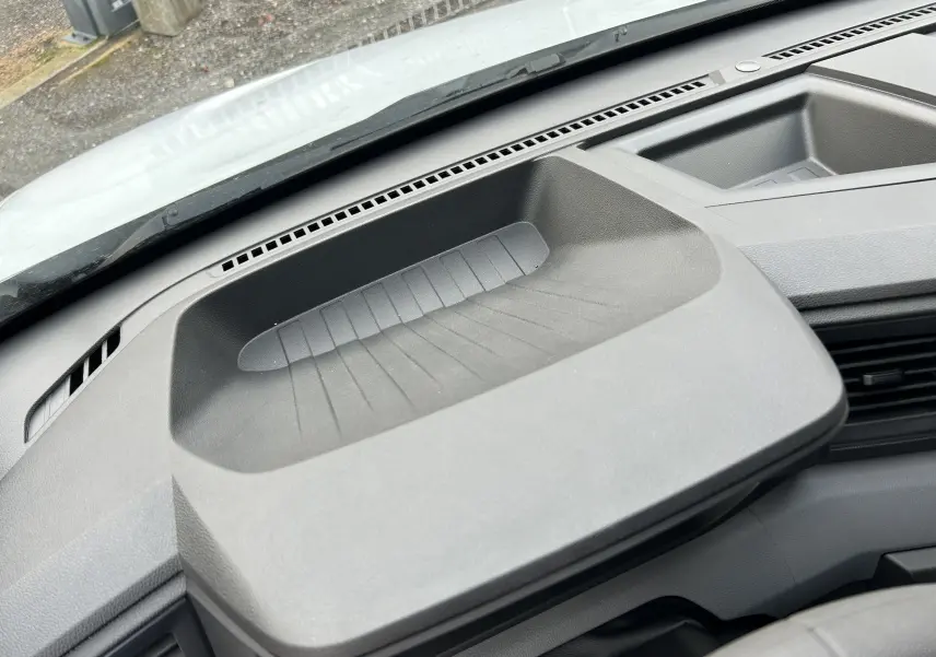 Vue rapprochée du plateau de rangement noir sur le tableau de bord du Renault Master blanc, intérieur avant.