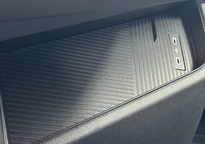 Gros plan sur la console centrale noire avec surface antidérapante et ports USB-C du Renault Master blanc.