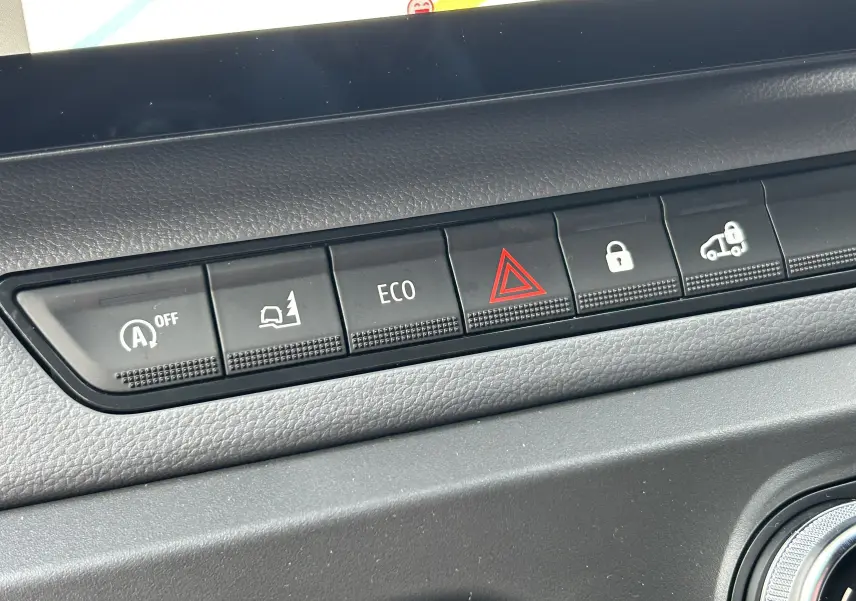 Gros plan sur la rangée de boutons de commande noirs du tableau de bord du Renault Master blanc, version 2025.