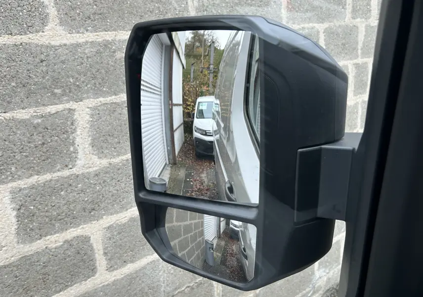 Rétroviseur latéral droit du Renault Master blanc 2025, reflétant la carrosserie et un autre fourgon blanc derrière.