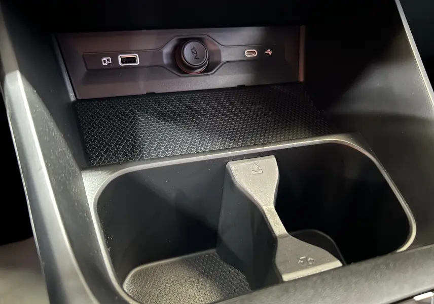Gros plan sur la console centrale noire du MG3 1.5 Hybrid+ 195 Luxury avec prises USB et prise 12V visibles.