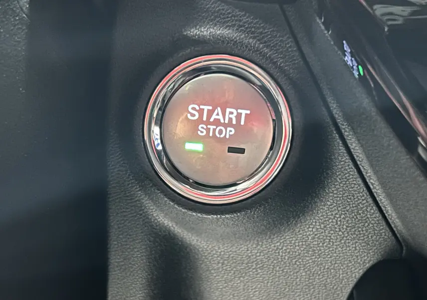 Bouton Start Stop rond avec éclairage vert sur tableau de bord en cuir noir du MG3 1.5 Hybrid+ 195 LUXURY 2026.