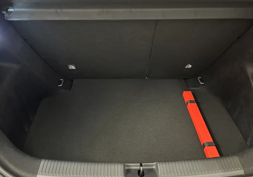 Coffre ouvert de MG3 1.5 Hybrid+ Pebble Black, vue de dessus montrant un triangle de signalisation rouge à droite.