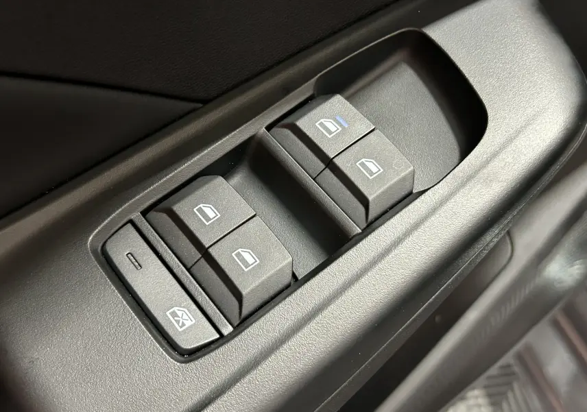 Gros plan sur les commandes de lève-vitres électriques côté conducteur de la MG3 Pebble Black 2026.