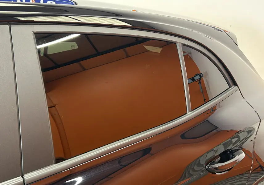 Vue rapprochée du côté gauche arrière de la MG3 Hybrid+ 195 Luxury Pebble Black avec vitre teintée et poignée chromée.