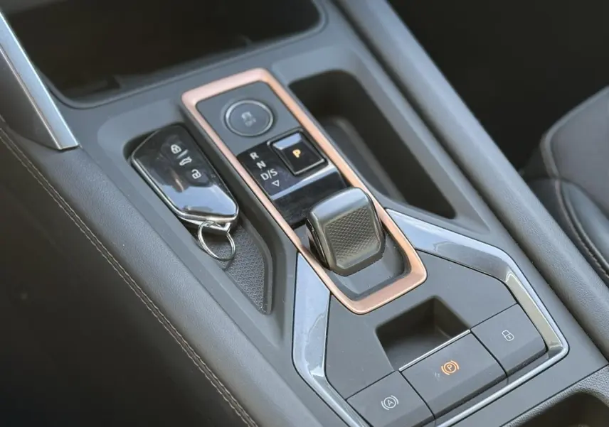 Gros plan sur la console centrale noire du CUPRA LEON ST 2025 avec levier de boîte auto et clé posée.