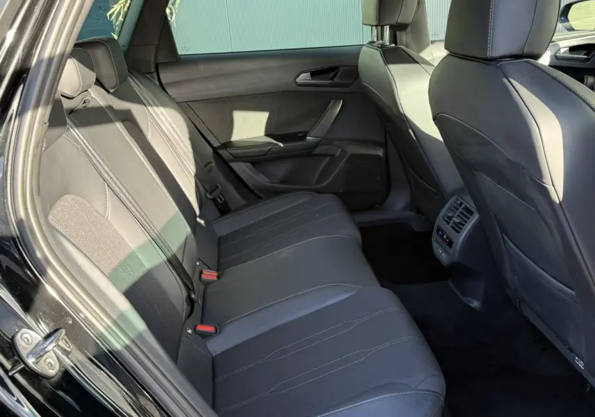 Vue intérieure côté gauche des sièges arrière noirs en cuir du CUPRA LEON ST 2025 avec coutures contrastées et aérateurs centraux.