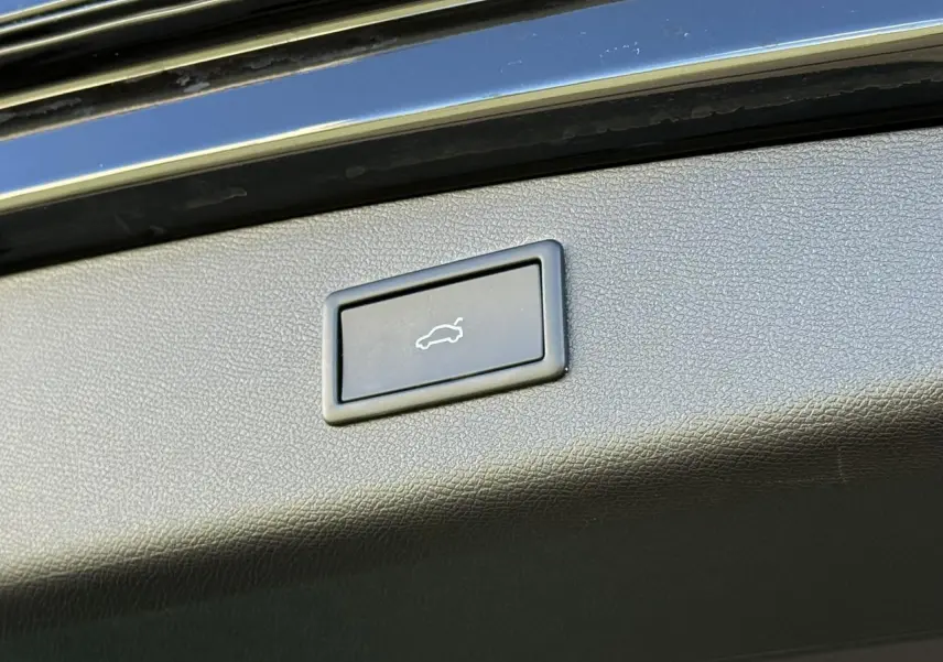 Bouton d'ouverture électrique du hayon sur la partie intérieure du coffre d'une CUPRA LEON ST noir Midnight 2025.