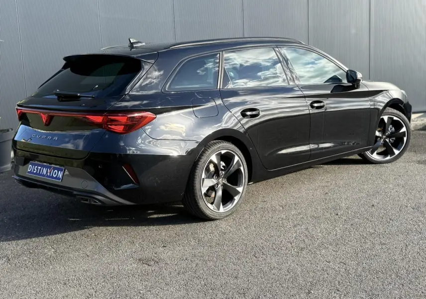 Vue 3/4 arrière droite d'une CUPRA LEON ST noire Midnight avec jantes alliage 18 pouces et bandeau lumineux arrière Tri-LED.