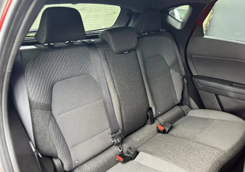 Vue intérieure sur les sièges arrière gris du Renault Captur 2025, avec ceintures et appuie-têtes visibles.