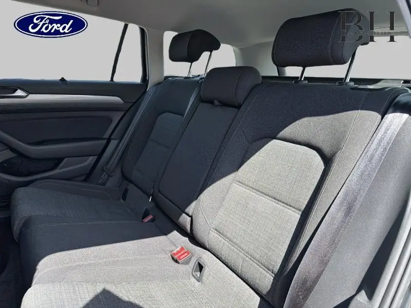 Vue intérieure de la banquette arrière en tissu noir titane d'une Volkswagen Passat SW 2.0 TDI, lumière naturelle.
