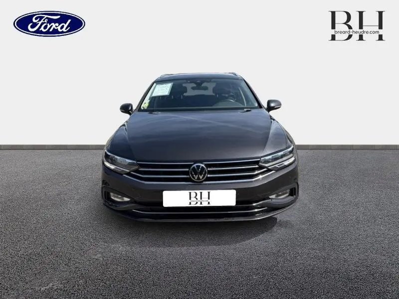 Vue avant d'une Volkswagen Passat SW 2.0 TDI gris manganèse métallisé avec calandre chromée et phares LED.