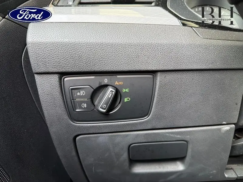 Commande des phares en gros plan sur tableau de bord noir, intérieur d'une Volkswagen Passat SW gris manganèse.