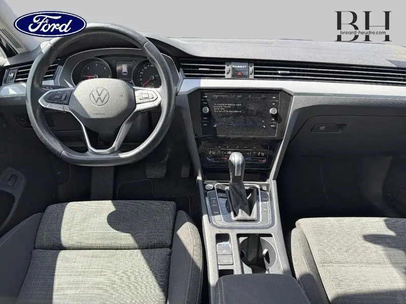 Vue intérieure avant de la Volkswagen Passat SW 2.0 TDI gris manganèse, avec volant multifonction et console centrale moderne.