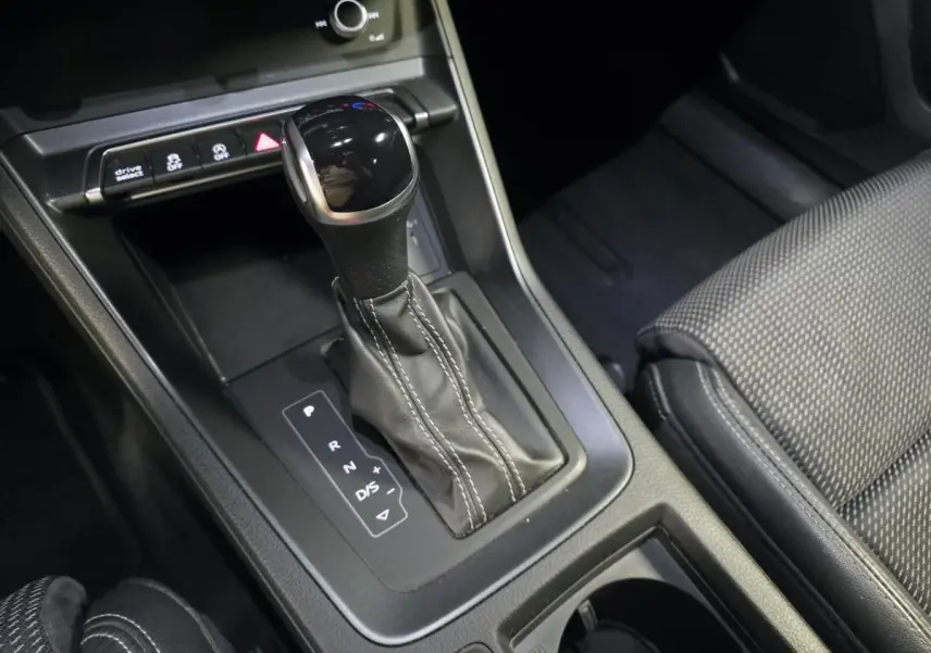 Gros plan sur le levier de vitesse automatique noir et cuir avec surpiqûres blanches dans l’Audi Q3 Sportback 2023.