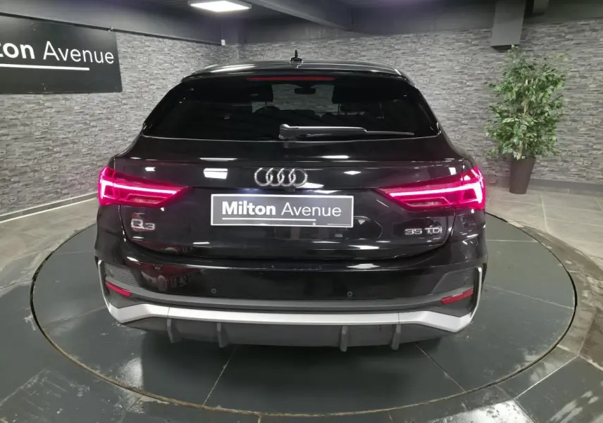 Vue arrière d'un Audi Q3 Sportback noir 2023 avec feux LED allumés et logo 35 TDI visible.
