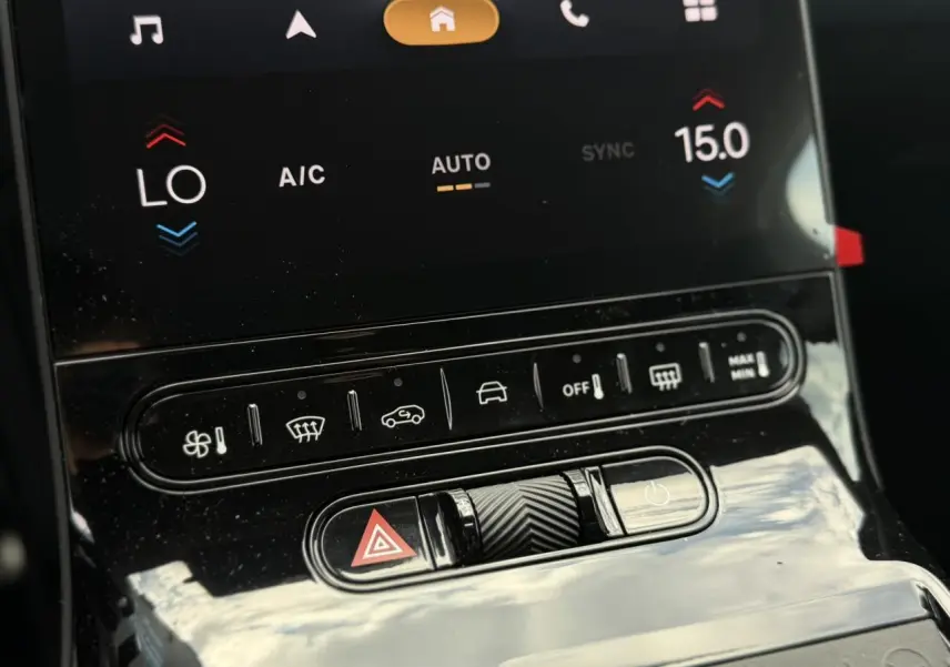 Gros plan sur la console centrale noire brillante du Citroën C5 Aircross avec commandes climatisation et bouton warning.