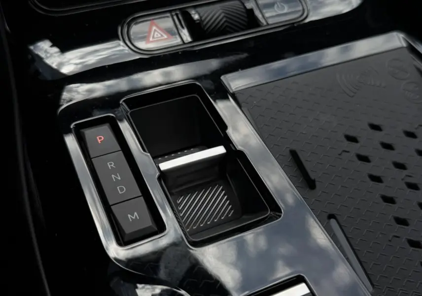 Gros plan sur la console centrale noire brillante du Citroën C5 Aircross hybride avec sélecteur de vitesses automatique.