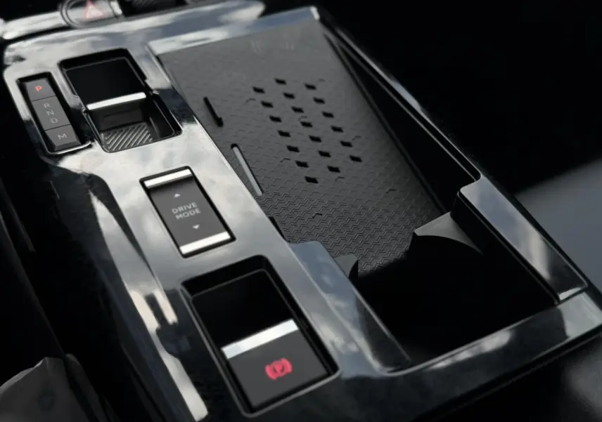 Gros plan sur la console centrale noire brillante du Citroën C5 Aircross Hybrid avec commandes de boîte auto et mode de conduite.