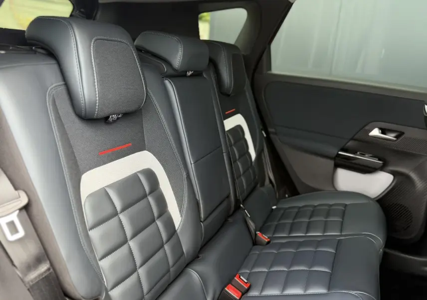 Vue latérale intérieure des sièges arrière en cuir noir et tissu avec surpiqûres et détails rouges du Citroën C5 Aircross.