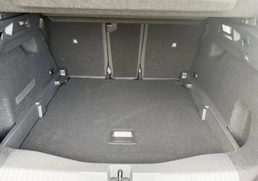 Coffre spacieux du Citroën C5 Aircross hybride 2026, vue intérieure arrière avec plancher modulable et revêtement noir.