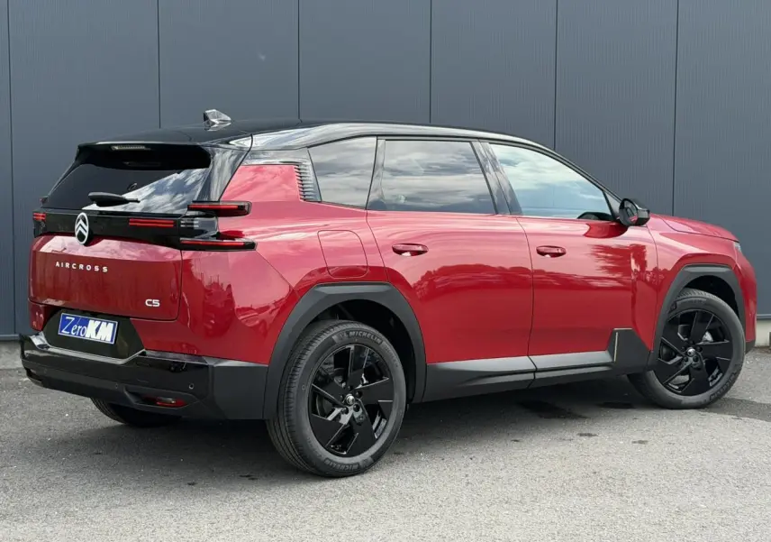 Vue 3/4 arrière droite du Citroën C5 Aircross rouge rubis avec toit noir et jantes alliage noires.