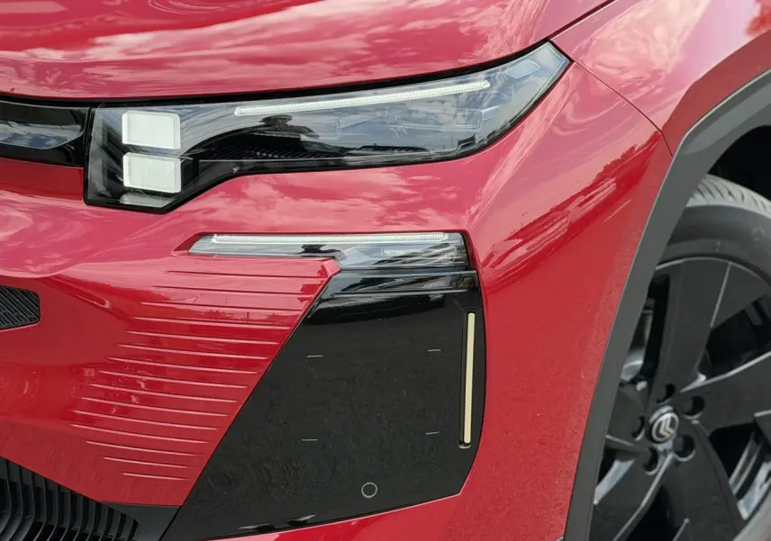 Gros plan sur l'avant droit rouge rubis du Citroën C5 Aircross avec optique LED et jante alliage noire.
