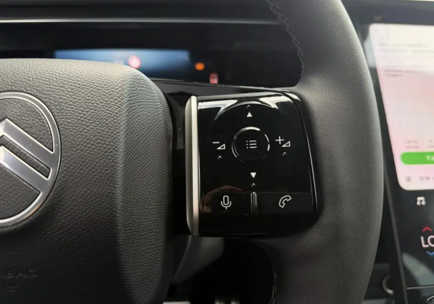 Gros plan sur les commandes tactiles noires à droite du volant gris foncé du Citroën C5 Aircross hybride 2026.