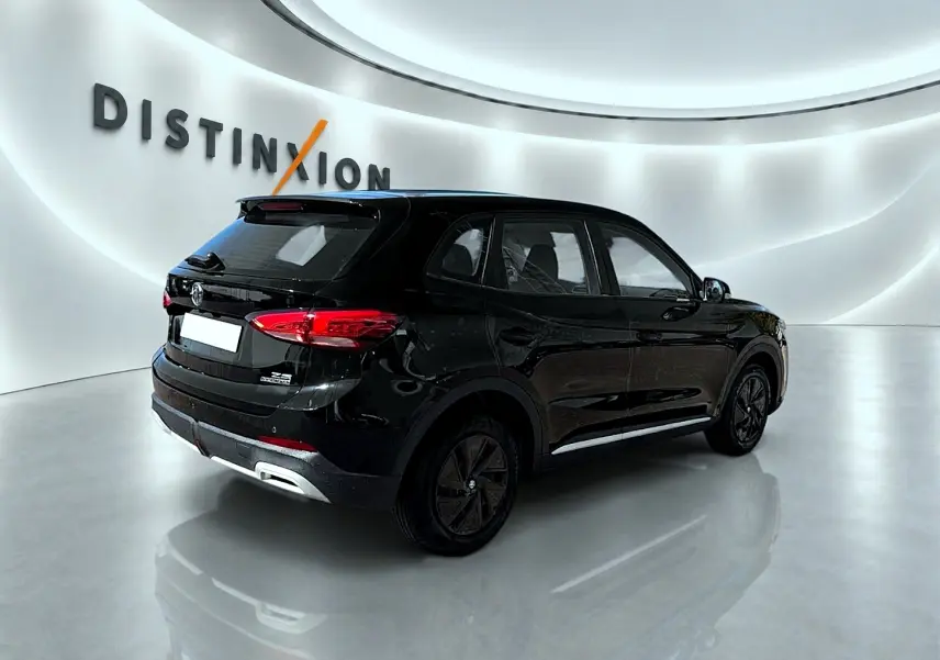 Vue 3/4 arrière droite du SUV MG ZS hybride noir, avec feux arrière LED et becquet arrière visible dans un showroom lumineux.