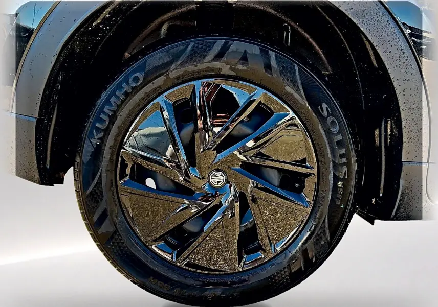 Gros plan sur la roue avant droite noire du MG ZS 1.5 hybrid 197 avec jante brillante et logo MG au centre.