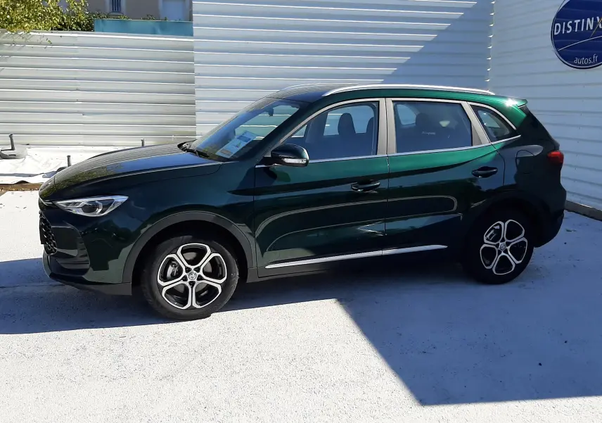 Vue de profil côté gauche du SUV MG ZS 1.5 Hybrid+ 197ch en vert émeraude avec jantes alliage bicolores.