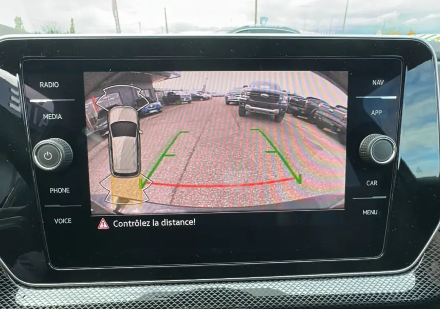 Écran multimédia affichant la caméra de recul du Volkswagen T-Cross noir intense, avec guidage de trajectoire verte et rouge.