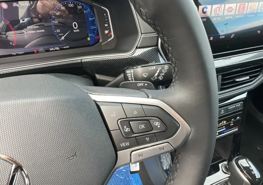 Gros plan sur le volant cuir multifonctions et le tableau de bord numérique du Volkswagen T-Cross TSI 116 DSG7 R-Line 2025 noir intense.