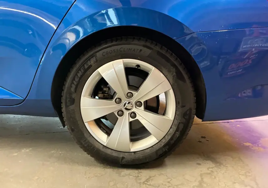 Gros plan sur la roue arrière droite d’une Skoda Superb Combi bleu, avec jante alliage argentée et pneu Michelin.