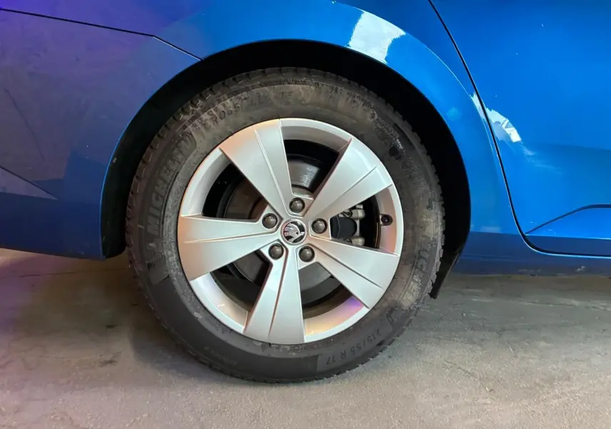 Gros plan sur la roue arrière droite d'une Skoda Superb Combi bleu 2021 avec jante alliage cinq branches.