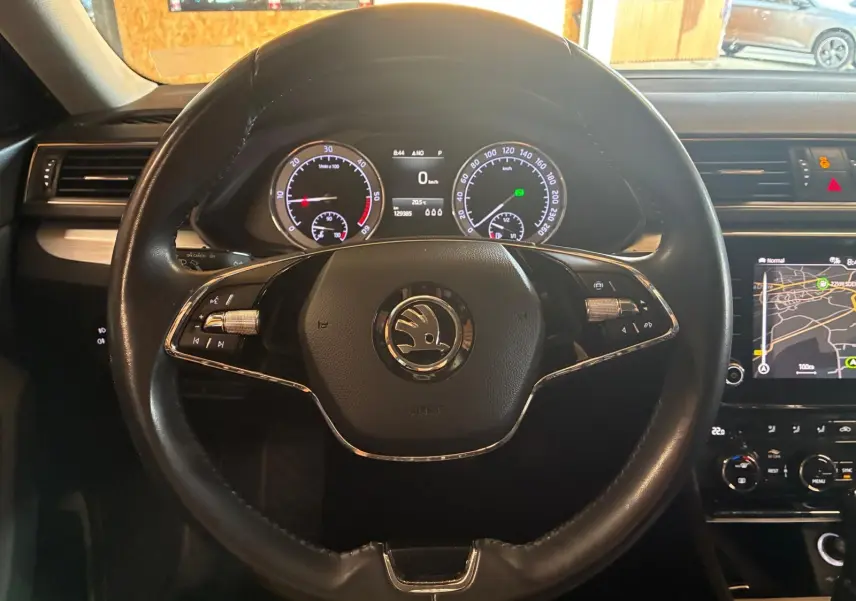 Vue centrée sur le volant noir du Skoda Superb Combi 2021, avec tableau de bord digital et écran GPS visible à droite.