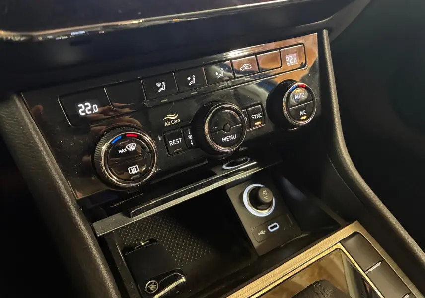 Gros plan sur la console centrale noire de la Skoda Superb Combi 2021, montrant les commandes de climatisation et prises USB et 12V.