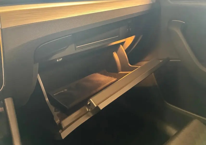 Gros plan sur la boîte à gants ouverte côté passager de la Skoda Superb Combi 2021 avec intérieur noir et rangement visible.