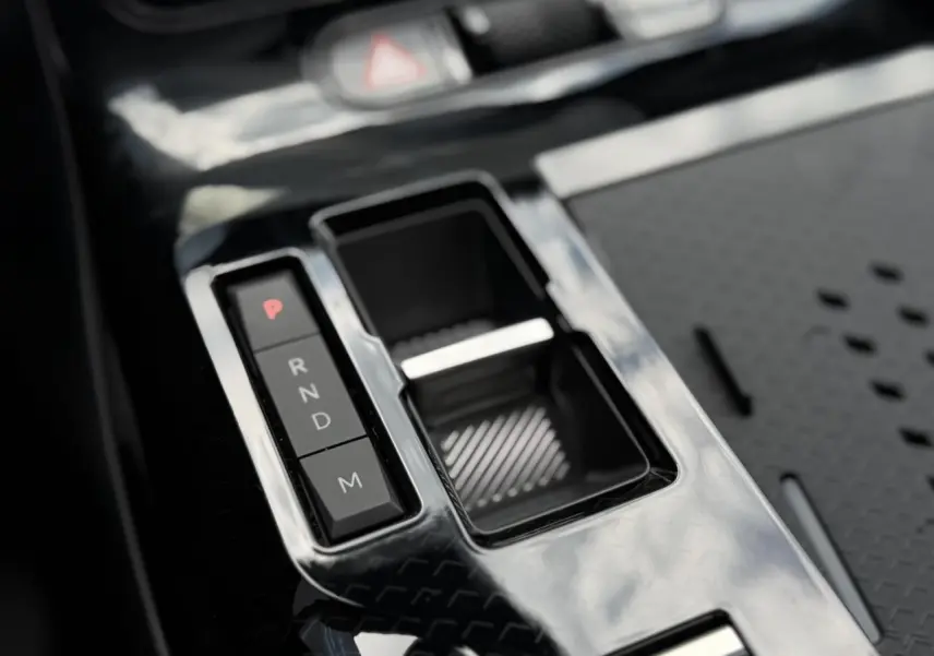 Gros plan sur la console centrale noire brillante avec sélecteur de boîte automatique du Citroën C5 Aircross blanc.