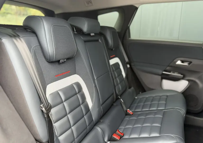 Vue latérale droite des sièges arrière en cuir noir et tissu gris du Citroën C5 Aircross 2026 avec détails rouges et ceinture de sécurité.